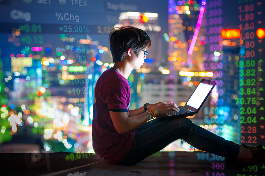 A man using a laptop on the rooftop of a skyscraper
